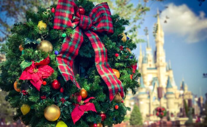 11A festive wreath hangs in the foreground, with the Magic Kingdom castle in the background